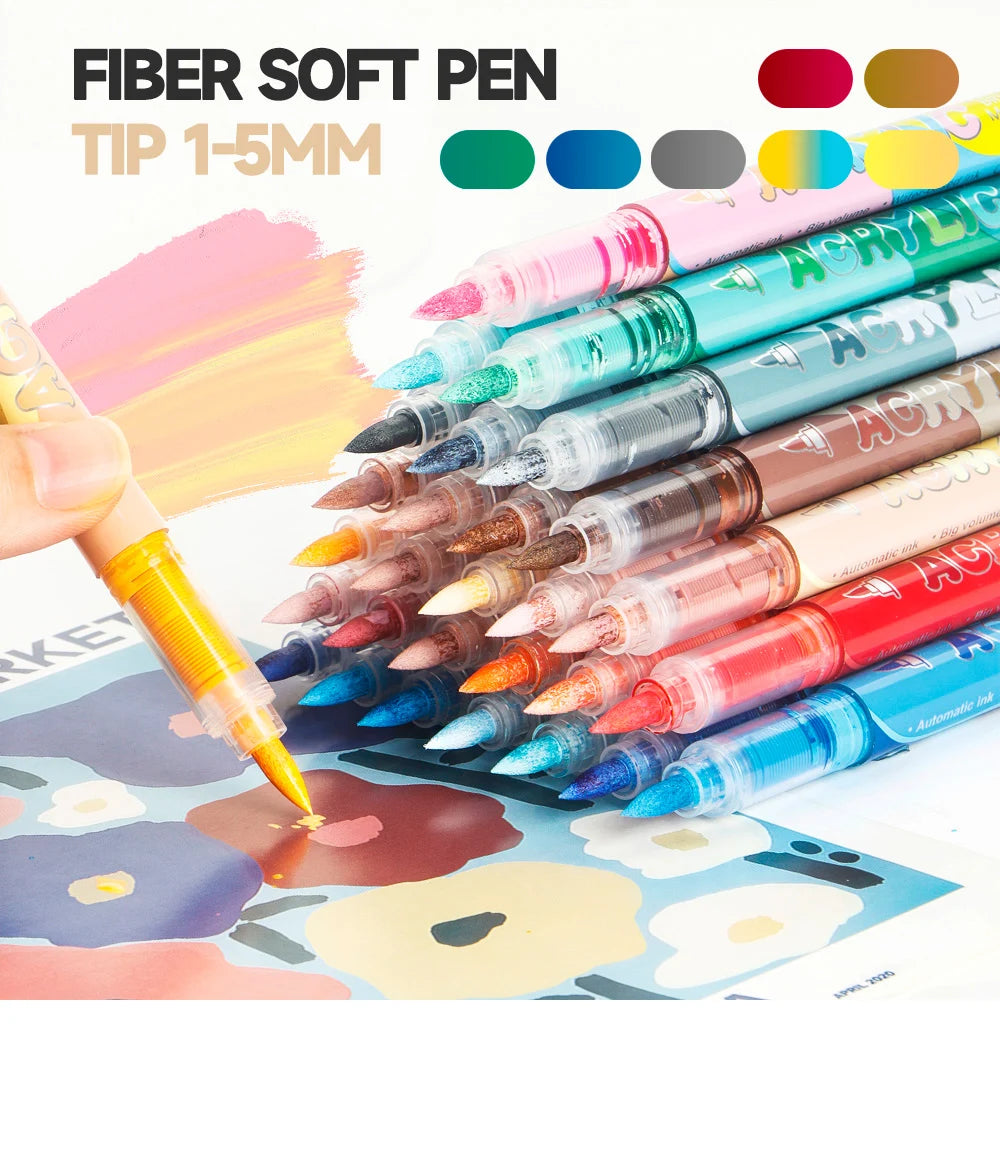 A collection of 12 fiber soft pen markers in various colors and shades laid out next to a hand using one of the pens on patte