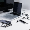 A silver laptop and a black stylus pen are displayed on a white desk.