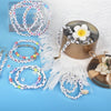 A collection of colorful alphabet letter beads and stringing materials for jewelry making displayed on a light blue surface.