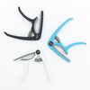 Three adjustable guitar capos in black, blue, and white with built-in bridge pin pullers.