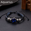 A black leather wrap bracelet featuring a blue glow in a silver charm, suitable for an Aquarius zodiac sign.