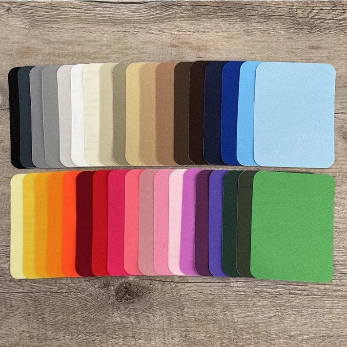 A collection of iron-on fabric patches in various shades of gray, beige, brown, blue, and teal.