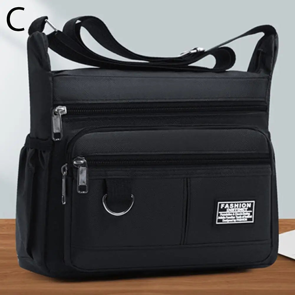 Black men's waterproof crossbody bag with multiple zippered pockets shown from the top.