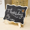 A mini wooden chalkboard sign shaped like a cloud, featuring handwritten text for Thursday juice and coffee.