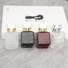 A row of four elegant glass perfume bottles with gold sprayers and a black silhouette graphic on the packaging.