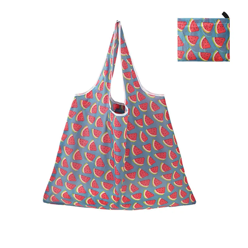 A reusable shopping tote bag patterned with sliced watermelon pieces in red and green on a blue background.