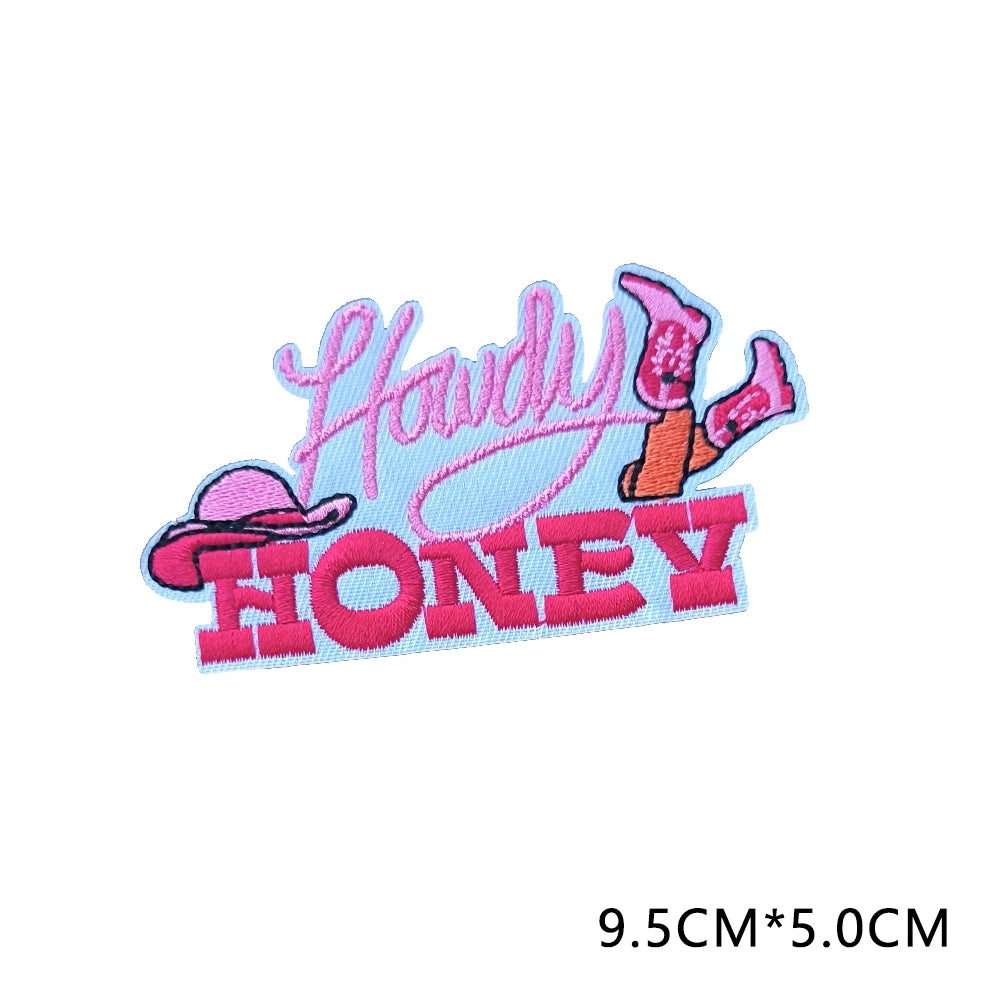 Pink and orange embroidered letter patches spelling 'Howdy Honey'