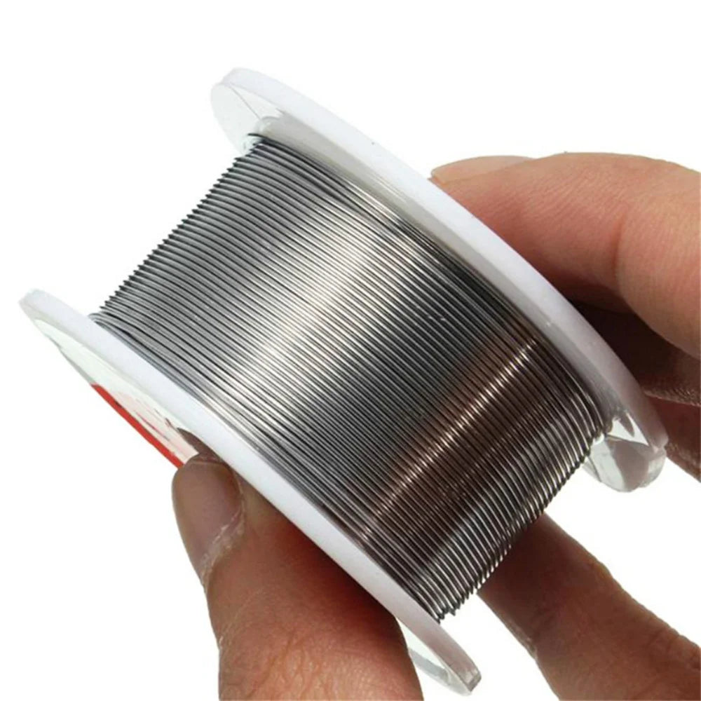 A hand holds a spool of rosin core solder wire in a clear plastic casing.