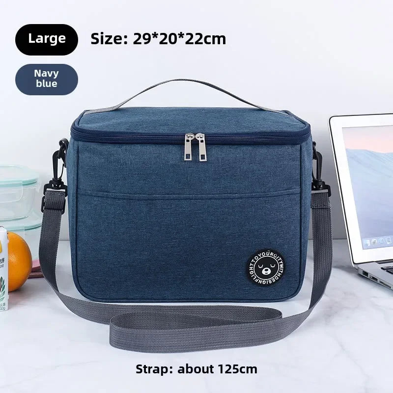 Navy blue insulated lunch bag with a gray shoulder strap shown on a white surface.