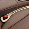 A beige car seat gap filler and organizer is shown inside a brown leather car seat.
