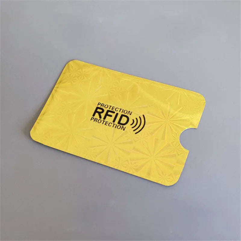 A yellow RFID blocking aluminum card holder placed on a gray surface.