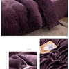 A close-up of a deep purple cozy flannel duvet cover with a zipper detail on a bed.