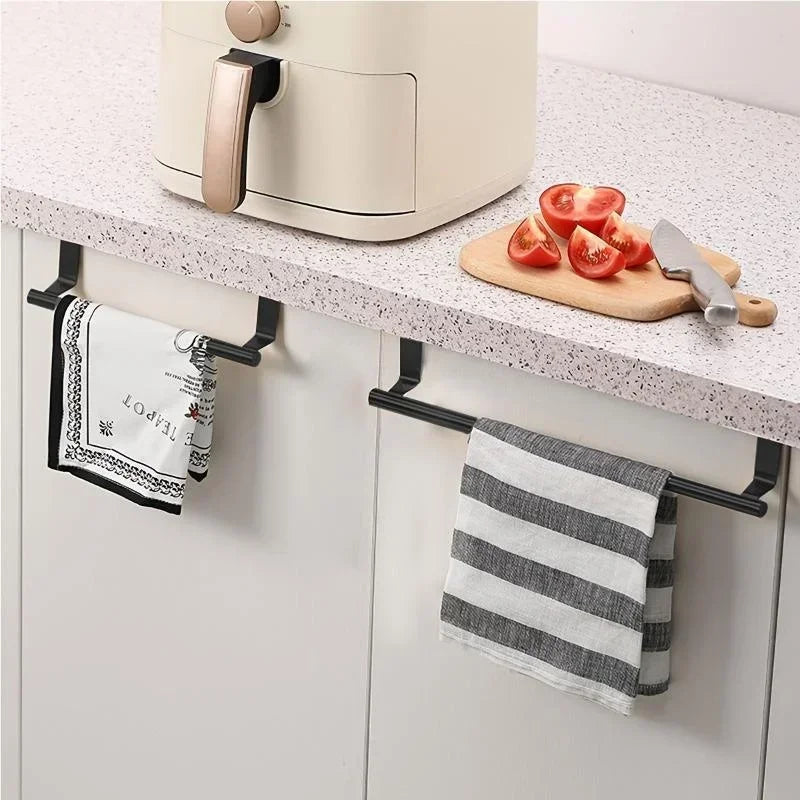 A white punch-free over-cabinet towel rack mounted under a kitchen cabinet, with a striped towel and a knife on the counterto