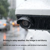 A close-up of a black rain cover protecting a car's rear camera lens while driving in the rain.
