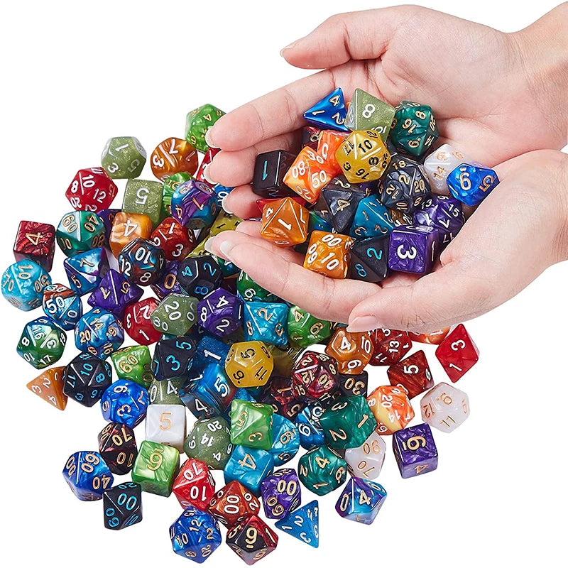 A hand holds a pile of multicolor polyhedral dice used for tabletop role-playing games.