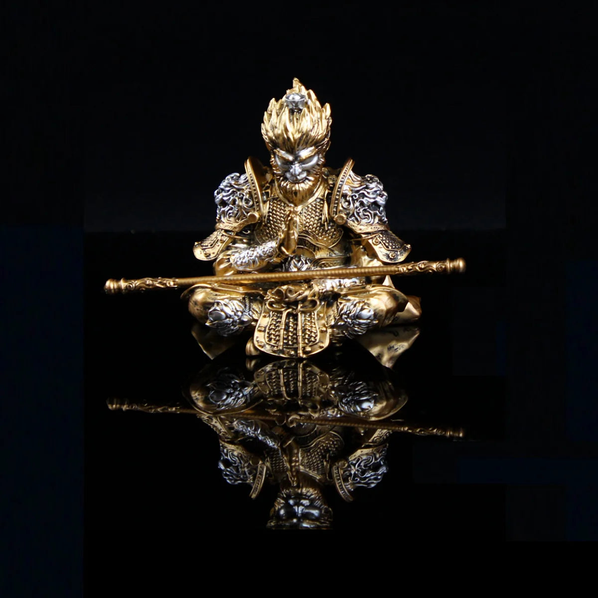 Gold hand-painted Monkey King figurine holding a staff, displayed against a black background.