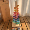 Holzregenbogen-Soundbaum mit farbenfrohen Blüten und einer Marmorschlange auf Holzoberfläche.