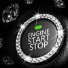 A close-up of a round button covered in clear rhinestones with a green indicator light, set against a dark leather background
