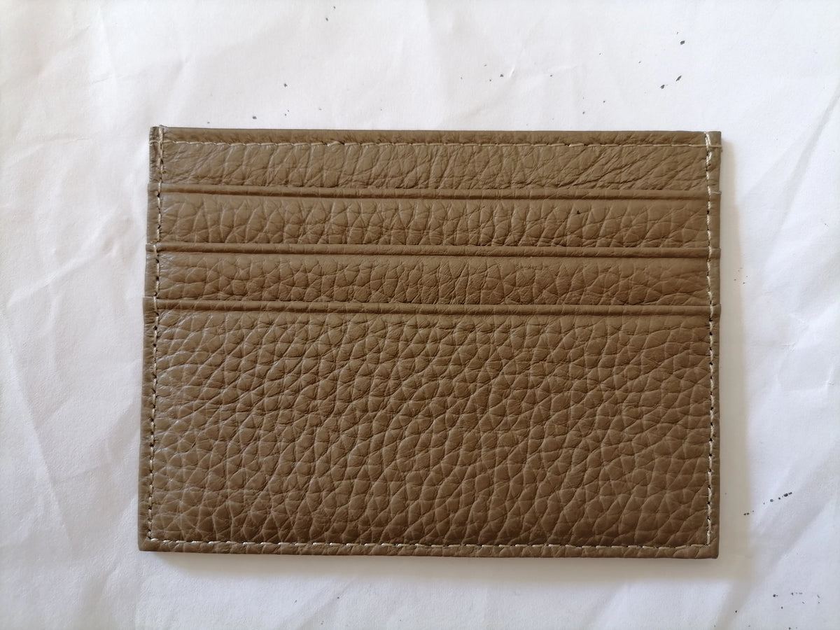 Porta tarjetas de cuero genuino marrón con costuras horizontales sobre fondo blanco.