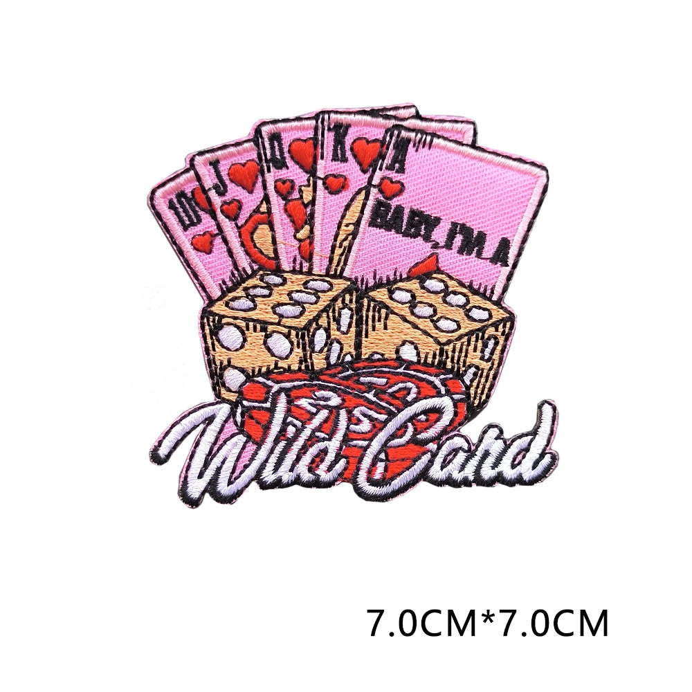 A set of pink and red embroidered letter patches featuring hearts and the text Wild Card.