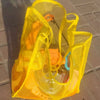 A bright yellow breathable mesh tote bag with an orange interior is shown in a daylight setting.
