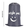 A grey drawstring laundry bag with the text wash me printed on it.