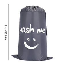 A grey drawstring laundry bag with the text wash me printed on it.
