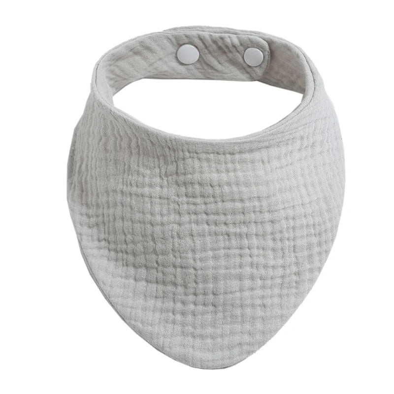 A light gray organic cotton muslin baby bib with an absorbent band around the neck.