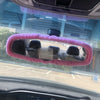 Rearview mirror covers made of pink plush material installed on a car interior.