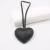 Black heart-shaped PU leather keychain with a cotton peach charm