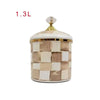 A cream and beige checkerboard porcelain storage jar with a gold lid.
