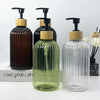 A set of three refillable soap dispensers in dark brown, green, and clear glass with wooden caps.