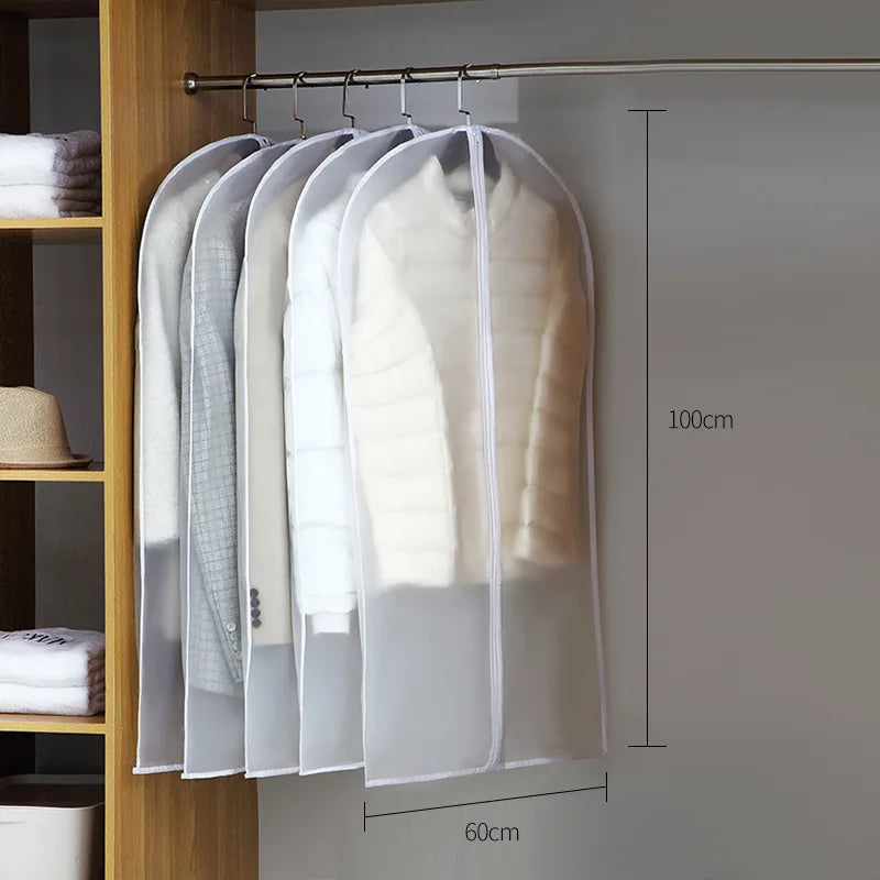 A transparent zippered garment bag with hangers displaying white and beige clothing items for storage.