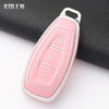 A pink silicone car key fob cover with three slots is shown resting on a black textured surface.