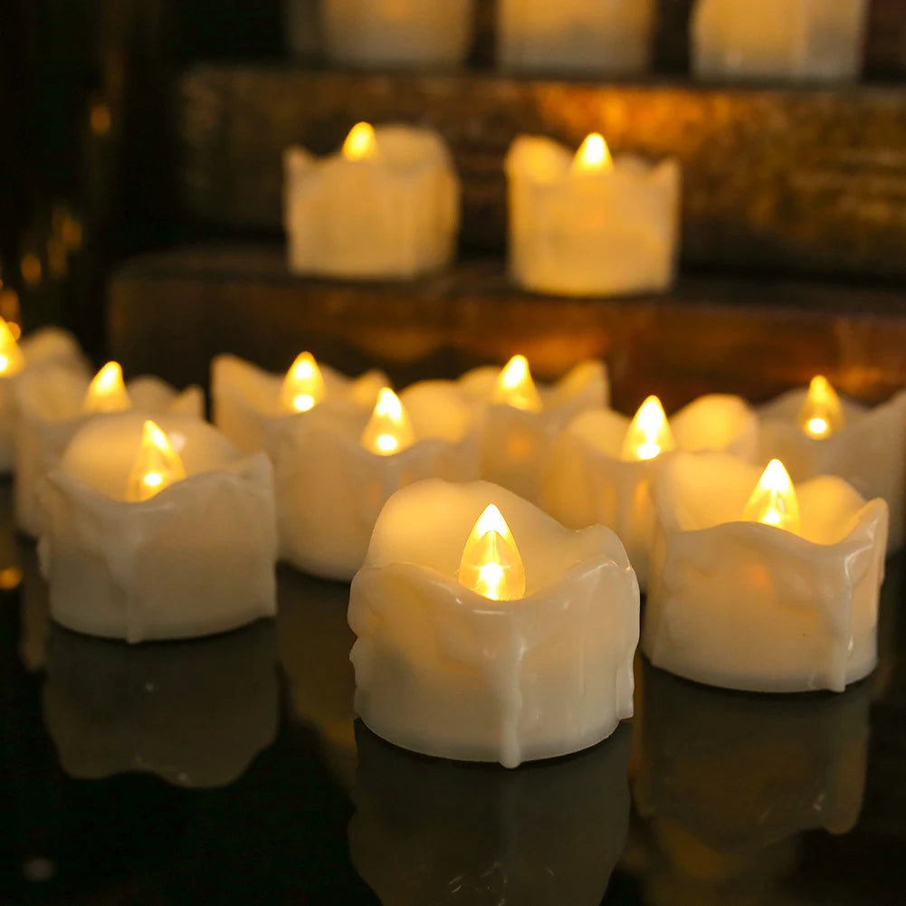 A row of glowing white LED tea light candles are displayed on a reflective surface.