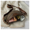 Braune und schwarze Leopardenmuster-Crossbodytasche mit braunem Lederriemen auf einem cremefarbenen Handtuch.