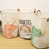 Three natural fabric storage baskets with cartoon animal prints, including a pink unicorn and a green dinosaur.