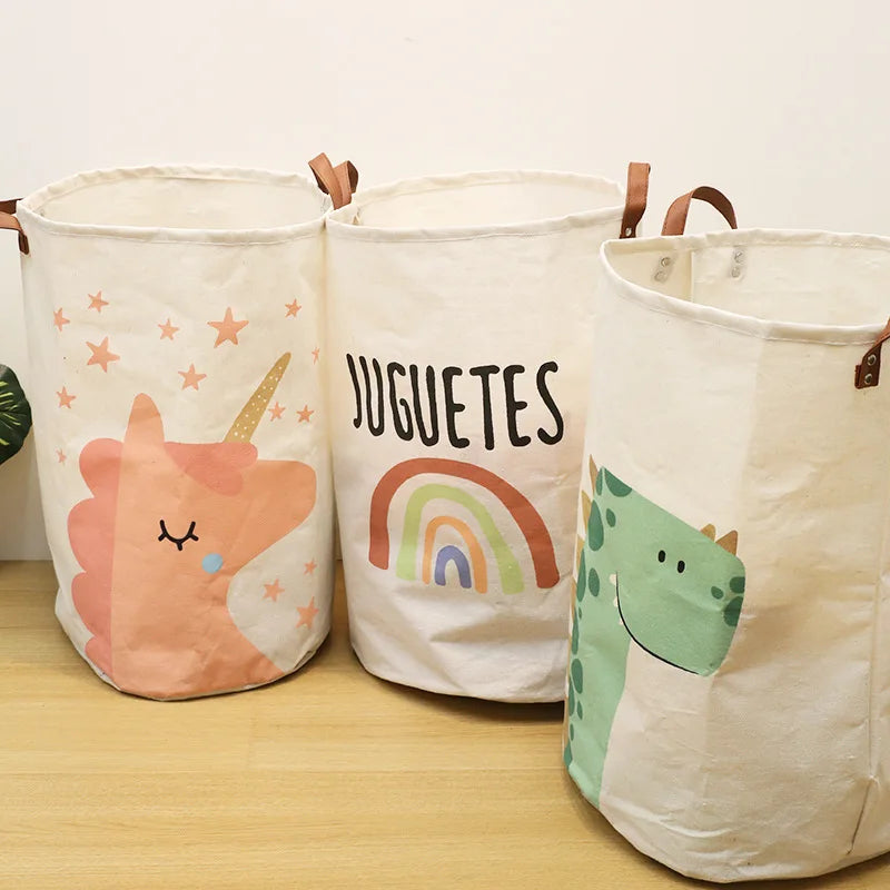Three natural fabric storage baskets with cartoon animal prints, including a pink unicorn and a green dinosaur.