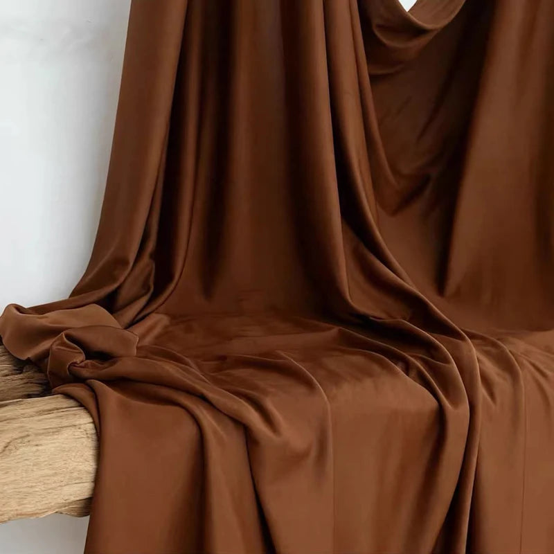 A close-up of rich brown stretch jersey fabric draped elegantly for decor or backdrop.