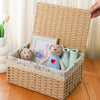 A handwoven rattan storage basket with a lid holds stuffed animals and a framed picture.