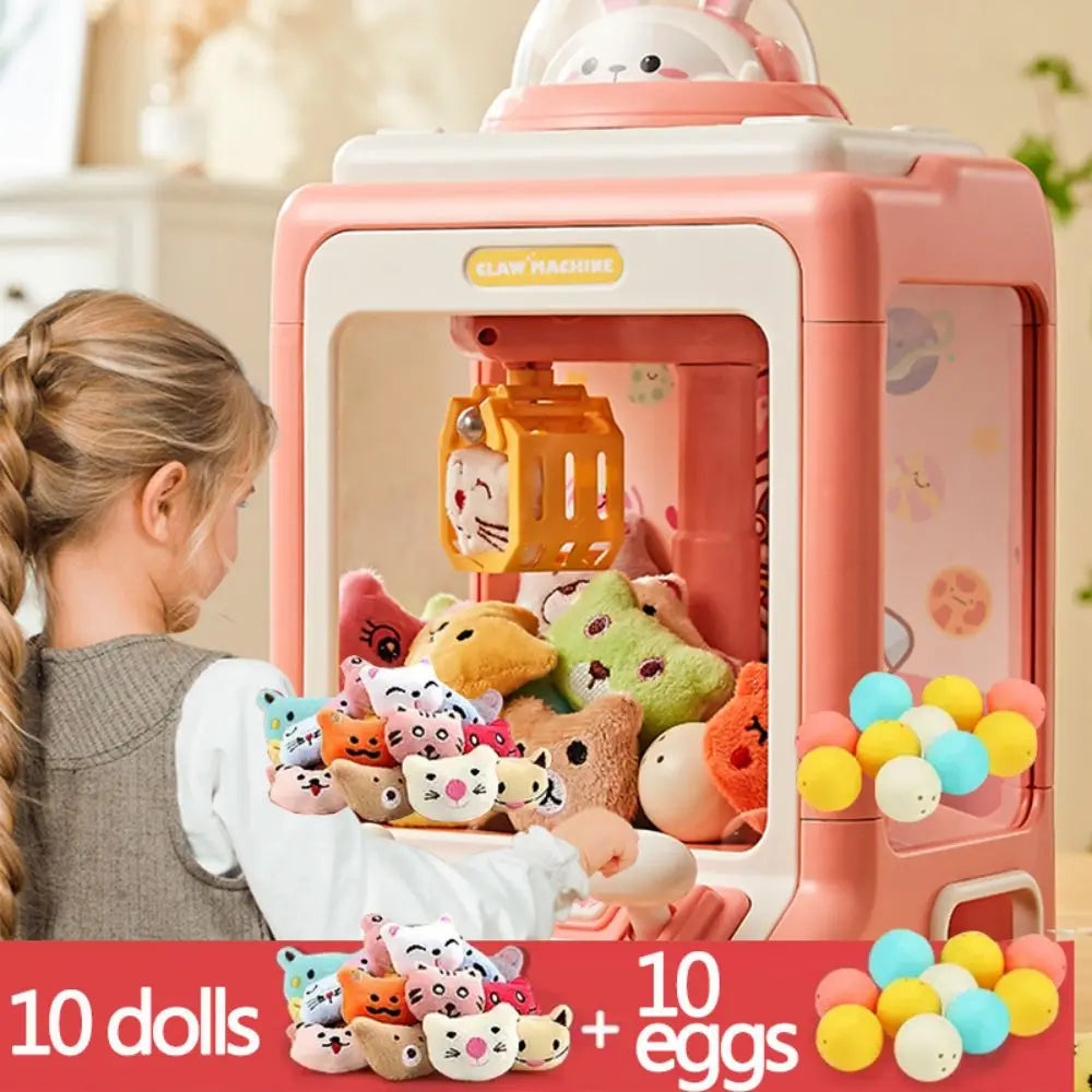 A pink mini claw machine toy for kids with lights and music, shown in a close-up view.