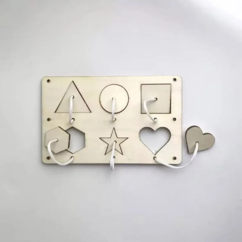 A brass Montessori busy board with five wooden shapes, including a triangle, circle, square, star, and heart.