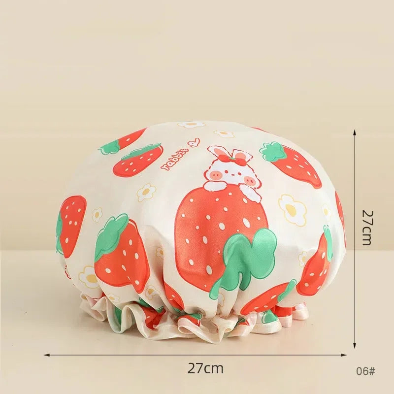 A reusable waterproof shower cap for hair care featuring a strawberry pattern in pink, green, and white.