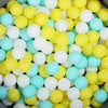 A large pile of colorful plastic ball pit balls in yellow, white, and light blue shades.