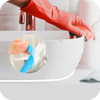 A hand in a red glove is applying waterproof self-adhesive tile gap tape to a white sink or countertop.