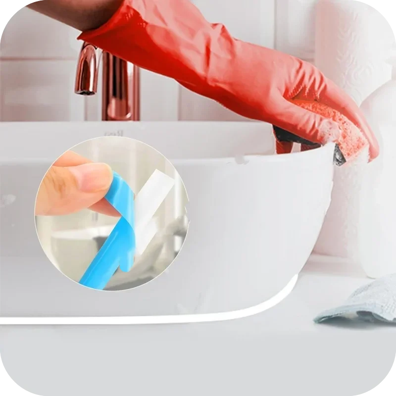 A hand in a red glove is applying waterproof self-adhesive tile gap tape to a white sink or countertop.
