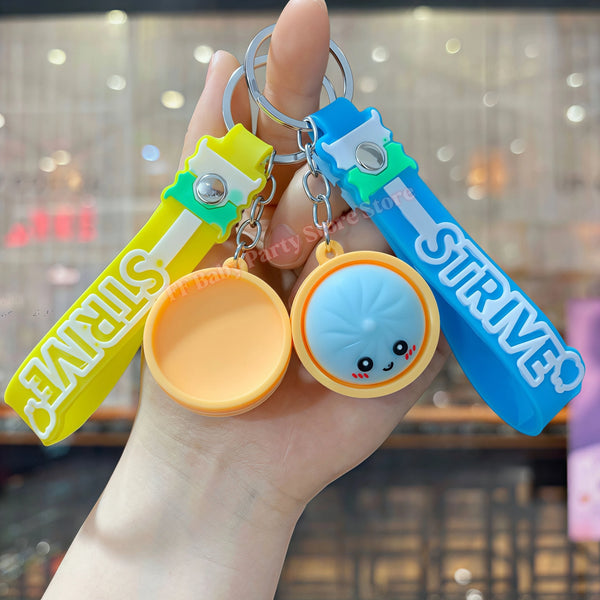 Eine Hand hält eine Set süßer Fidget-Dumpling-Anhänger in Gelb und Blau.