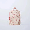 A light pink backpack with a cute cow print pattern and pink accents.
