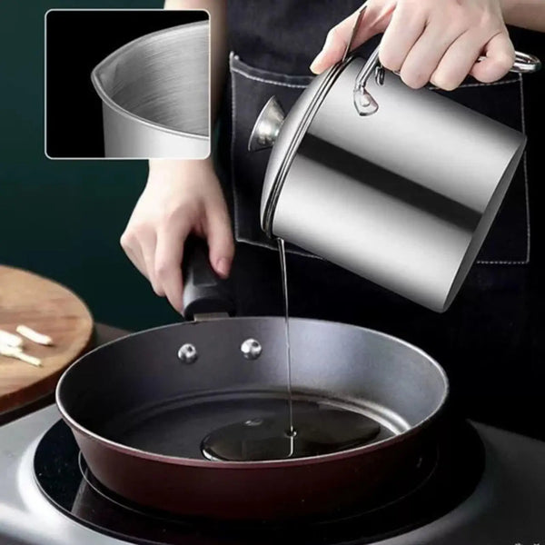 A hand pours oil from a stainless steel dispenser into a frying pan on a stovetop.