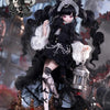 A highly detailed black and white doll dressed in gothic attire with lace and dark hair, displayed on a decorative stand.